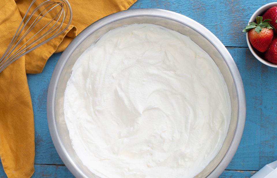 Bowl of whipped cream with fresh strawberries