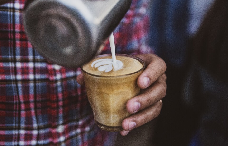 hand pouring latte