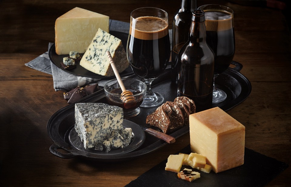 Glass of beer with smoked cheddar, blue cheese and crisps